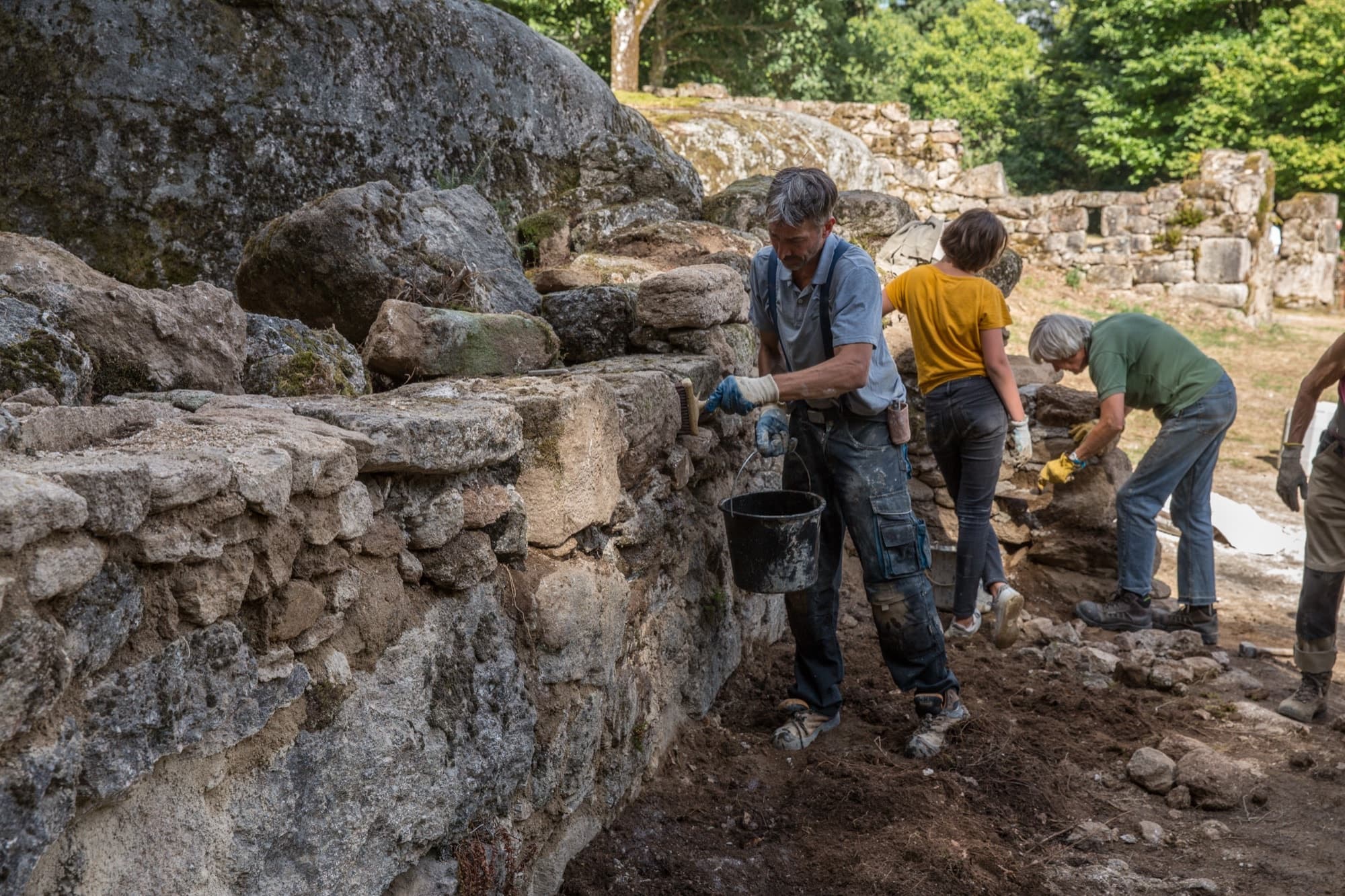 Brossage d'un mur en pierre lors d'une finition de chantier