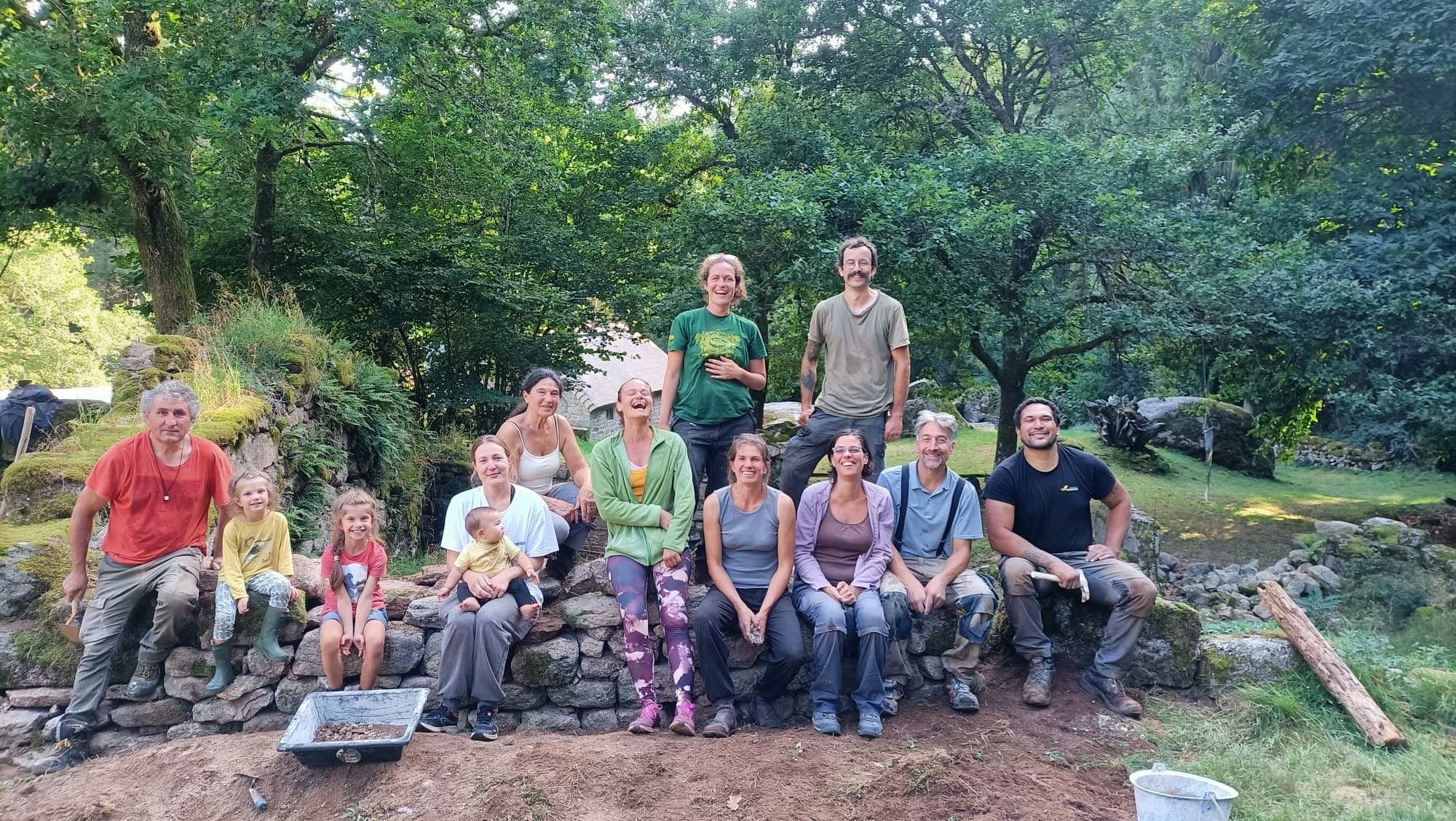 Équipe complète et famille souriantes après une journée de chantier